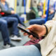 Persona con smartphone in metropolitana