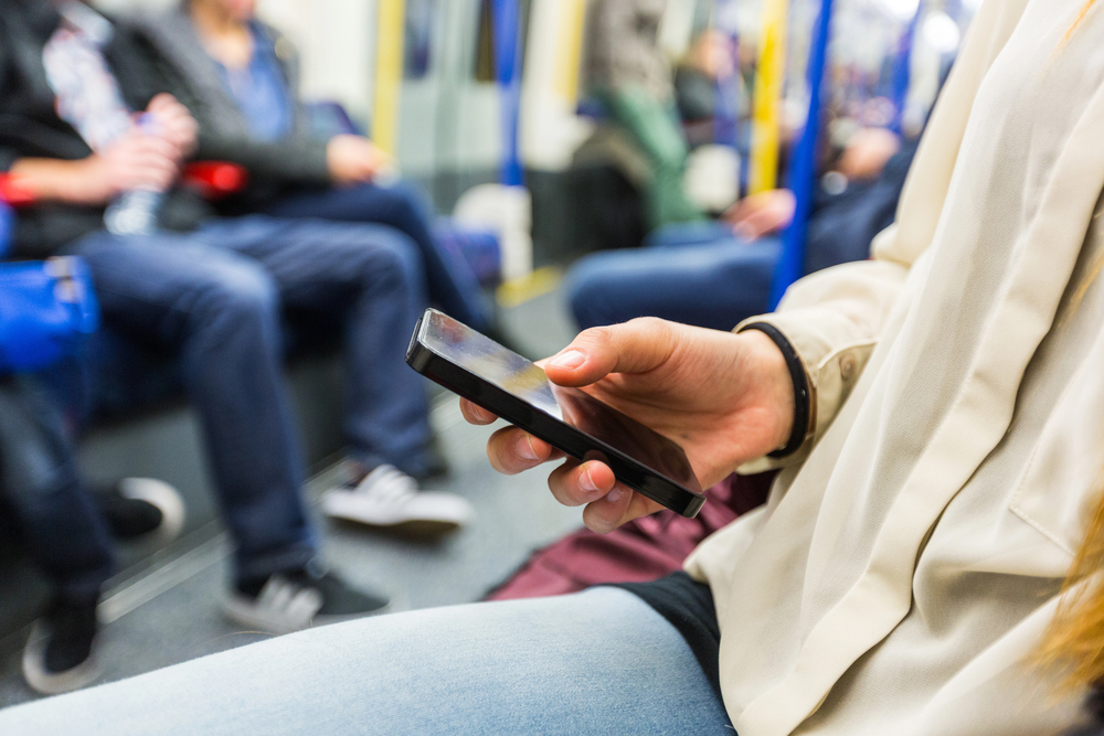 Persona con smartphone in metropolitana